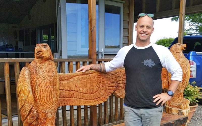 Roland Heming stood by a wooden carved eagle